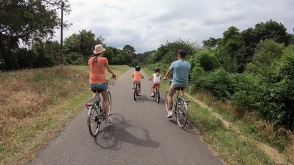 Kids with parents riding bikes in countryside