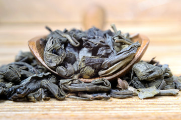 Green tea in a wooden spoon on the table