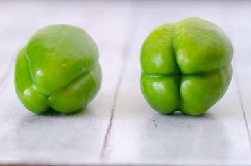 Raw and Fresh Green Organic Bell Peppers On Wooden Table.