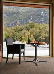 One glass of champagne on background big window and beautiful landscape beyond it.	


