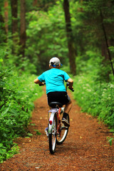 Fototapeta na wymiar Boy with bicycle in the forest.