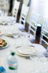 Sparkling glassware stands on long table prepared for wedding