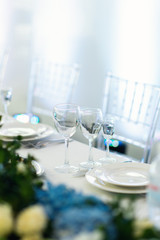 Sparkling glassware stands on long table prepared for wedding