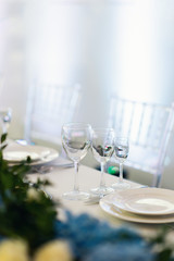Sparkling glassware stands on long table prepared for wedding