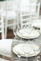 Sparkling glassware stands on long table prepared for wedding