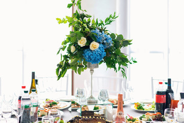 Banquet table is decorated with compositions of hydrangea flowers and greenery