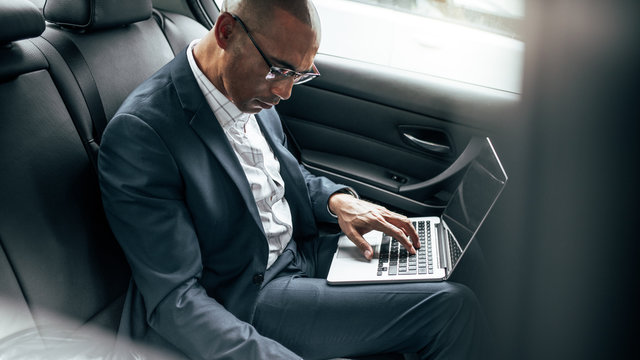 Businessman using laptop sitting in car