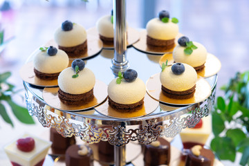 Cupcakes with blueberry on cake stand. Banquet table