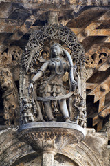 Shilabalika, celestial maiden, as a Dolu Kunita. A lady is palying a drum and dancing . Chennakeshava temple, Belur, Karnataka. Notice the hairstyle.