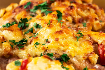 Meat dish of chicken, baked in the oven with vegetables under cheese crust, sprinkled with chopped parsley.