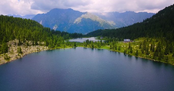 Aerial image of a lake surrounded by nature among trees and mountains. 