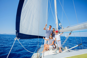 Family with adorable kids resting on yacht - obrazy, fototapety, plakaty