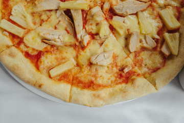 Enjoying the great tastes of Italian cuisine. Pizza with bacon and cheese on white table.. Fast food concept. Italian dish fork, knife. Served table in Italian restaurant, cafe or pizzeria.