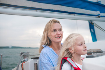 Caucasian family mother and daugther enjoy their day on a sail boat yacht
