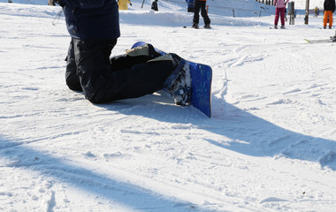 Snowboarding legs on winter mountain top. Snowboarder is riding from snow hill