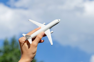 Naklejka na ściany i meble Airplane model in hand on sunny sky. Concepts of travel, transportation