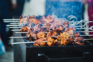 Chicken skewers grilling on a barbecue on top of charcoal grill