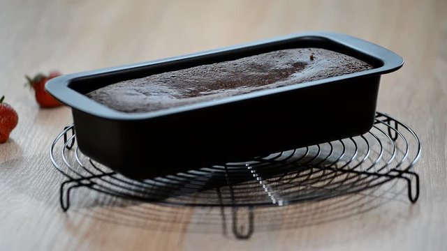 Freshly baked chocolate cake in cake form on wooden background, Baking chocolate cake ingredients