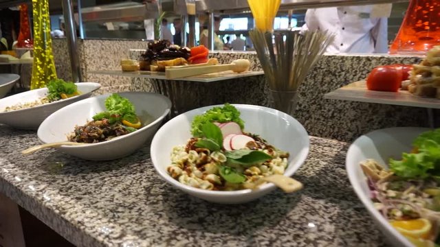 Numerous types of salads and snacks in the buffet restaurant. The point of view of the person choosing food.