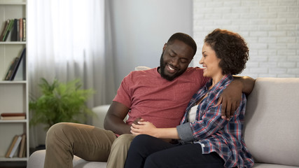 Love couple in waiting room of family planning clinic, dreaming about baby