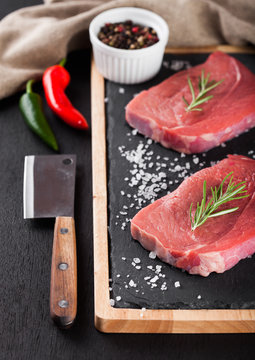 Fresh raw beef steak meat on board with hatchet