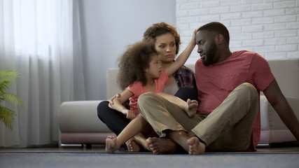 Caring daughter touching fathers forehead, checking temperature of sick dad