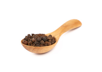 Wooden scoop spoon full of black peppercorns