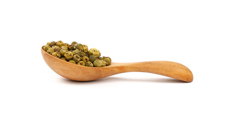 Wooden scoop spoon full of green peppercorns