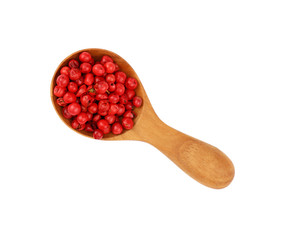 Wooden scoop spoon full of pink peppercorns