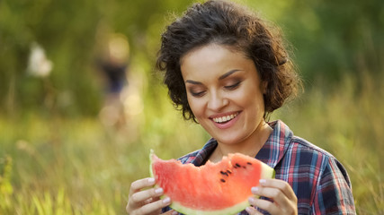 Woman enjoying fresh and juicy watermelon in back yard, healthy eating, summer