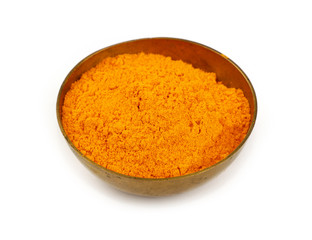 One bronze metal bowl full of yellow turmeric powder