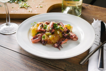 Alluring dish made of grilled squid and baked potatoes. Close up.