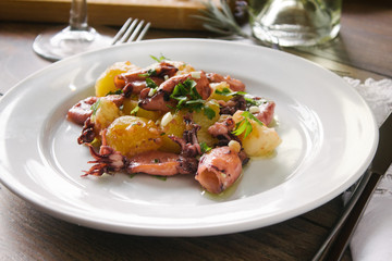 Alluring dish made of grilled squid and baked potatoes. Close up.