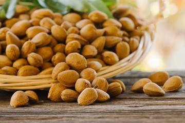 Pile of fresh raw almonds on a rustic wooden table.