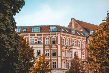 Fototapeta na wymiar historical apartment houses at berlin framed by autumn trees