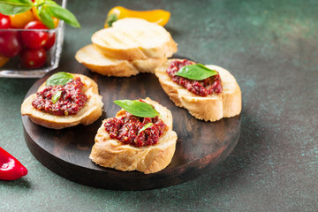 Bruschetta with tomato sauce and basil. Fresh baguette, tomatoes on wooden serving board.