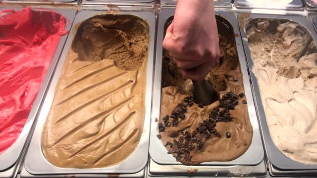 Scooping different flavors of gelato Italian style ice cream