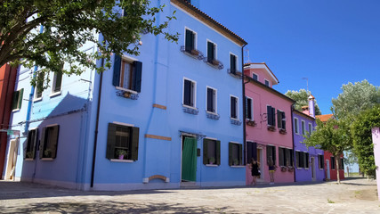 Fototapeta na wymiar Tourists walking near beautiful tidy colorful houses on Burano island, Venice
