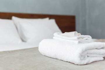 Fototapeta na wymiar White towel on bed in guest room for hotel customer