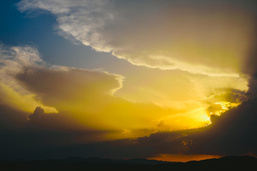 Beautiful sunset with the sun of orange tones behind the mountains and deep blue sky