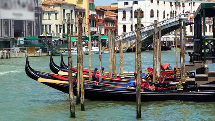 Fototapeta na wymiar Beautiful gondolas docked in Venice Canal, water transport, sightseeing tour