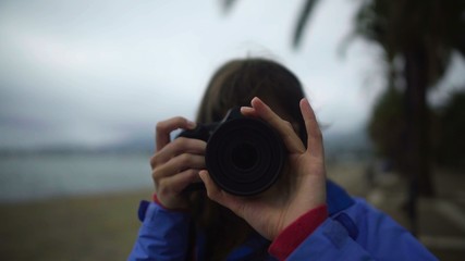 Girl photographer adjusting lens on camera, taking pictures at leisure, hobby