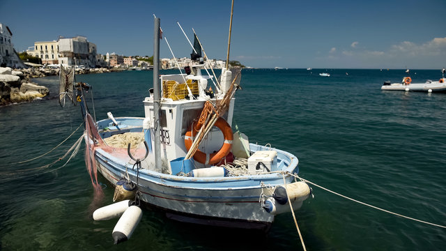 Fishing boat floating on water, drift nets lying on deck, small business