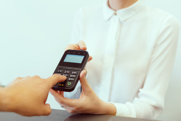 Guest at hotel reception paying with check during check-in