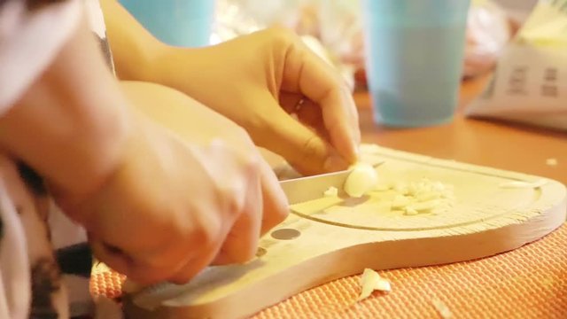 Slow motion video of cooking and cutting garlic