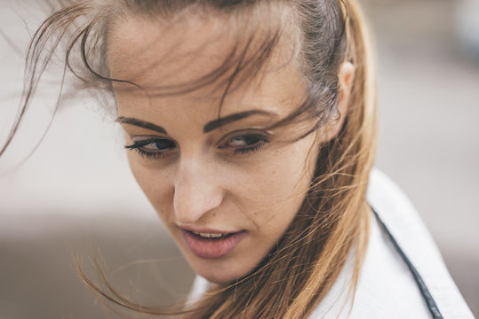 Portrait of sportive young woman outdoors turning round
