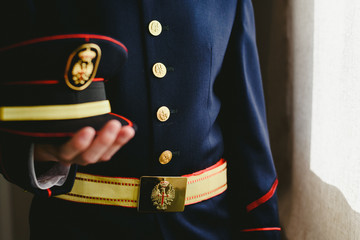 Soldier wearing uniform dress holding his cap.