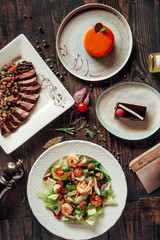 menu composition of dishes decorated with included seafood salad, meat and cake