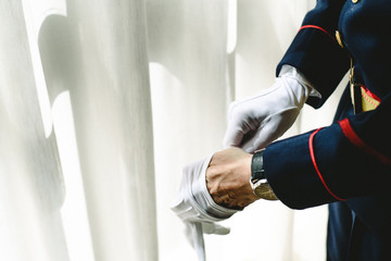 Military man hands putting on some elegant white gloves.