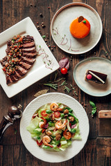 menu composition of dishes decorated with included seafood salad, meat and cake